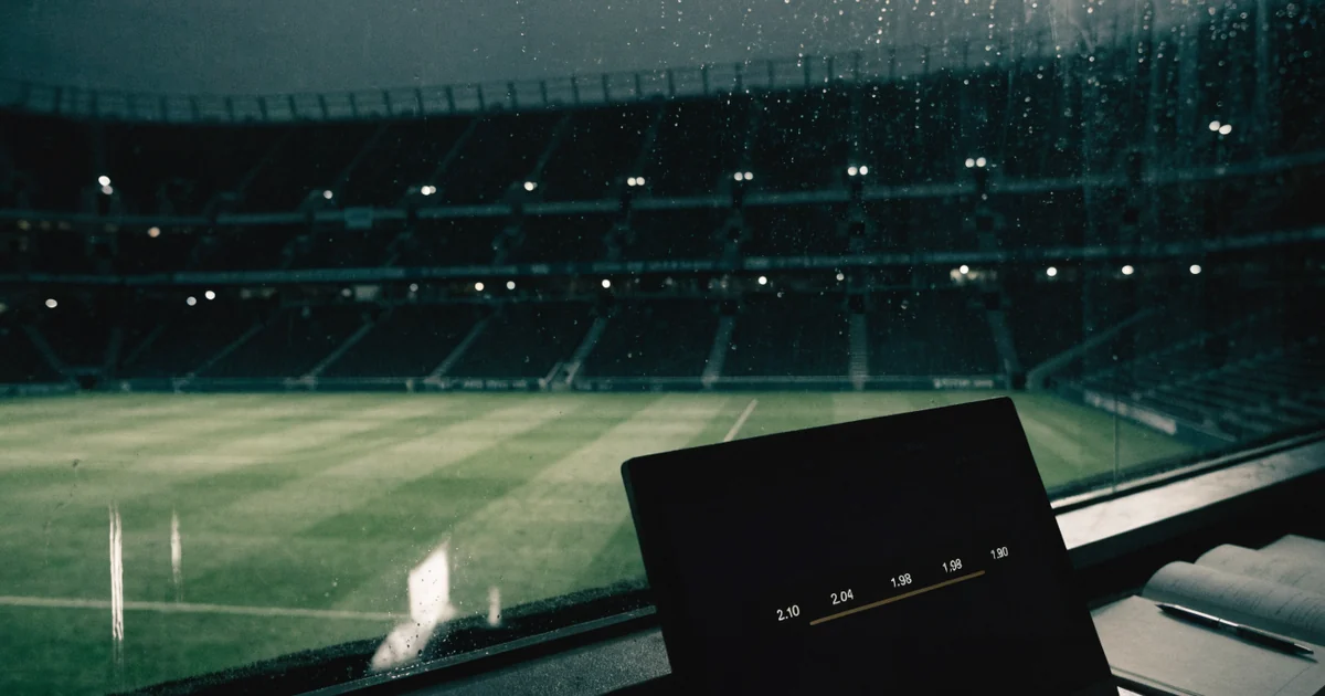 Betting odds moving on a monitor overlooking a football stadium before kickoff